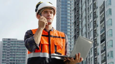 Engineer checking information from laptop talking on radio call with colleague Stock Footage 271662703