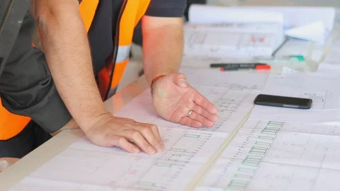 Engineer checking measures in architectural sketches on  a construction site.  스톡 동영상 99973456