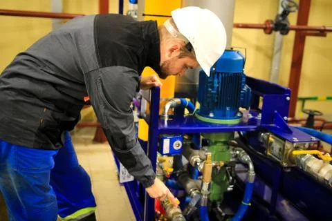 Engineer checking oil pump and pressure gauge in industrial plant. Stock Photos