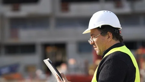 Engineer checking plans on a digital tablet Stock Footage 88653976