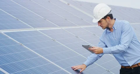 An engineer is checking with tablet an operation of photovoltaic solar panels. Video stock 115400276