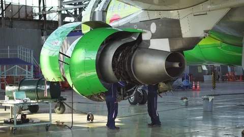 Engineer checks the aircraft engine. Aircraft repair in the hangar.  Stock Footage 84457362