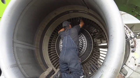 Engineer checks the aircraft engine. Aircraft repair in the hangar Stock Footage 84461721