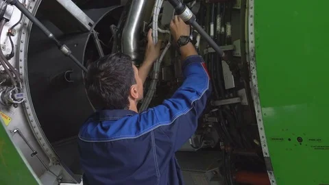 Engineer checks the aircraft engine. Aircraft repair in the hangar.  Stock Footage 84464438