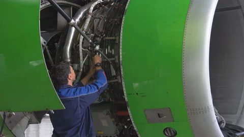 Engineer checks the aircraft engine. Aircraft repair in the hangar.  Stock Footage 95638225