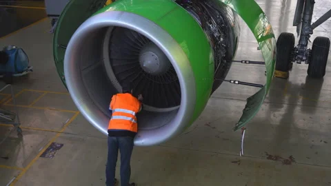 Engineer checks the aircraft engine. Aircraft repair in the hangar.  Stock Footage 95642006