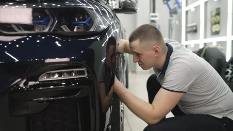 Engineer checks car in auto service. Car repair and detailing, worker checks Stock Footage 297879530