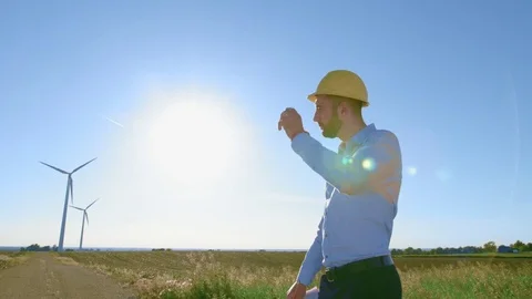 The engineer checks the drawings of the windmill, looks at the windmill. Video stock 76588725