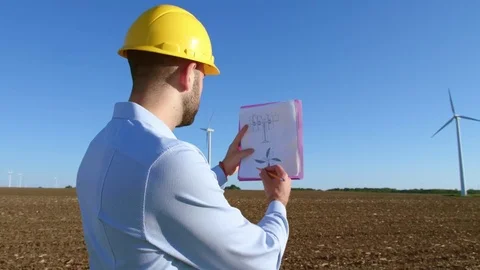 The engineer checks the drawings of the windmill, looks at the windmill. Stock-Footage 76639344