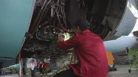 Engineer checks the engine of the aircraft. The repair of aircraft in the hangar Stock Footage 98003101