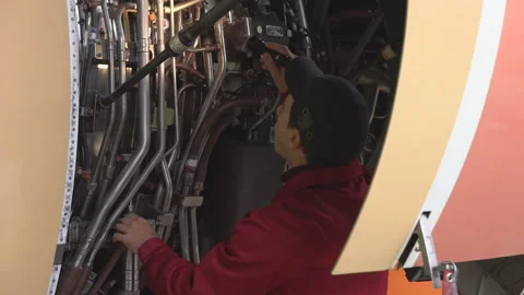 Engineer checks the engine of the aircraft. The repair of aircraft in the hangar Stock Footage 98006862