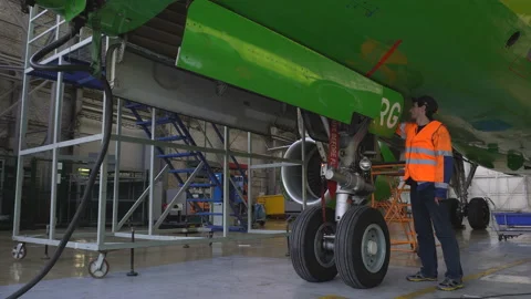 Engineer checks the operation of the hatch of the front landing gear of the Stock Footage 95648470