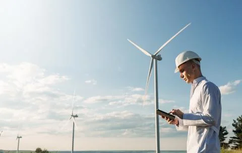 Engineer checks Wind Turbine system with a tablet. Alternative Energy. Wind farm Stock Photos