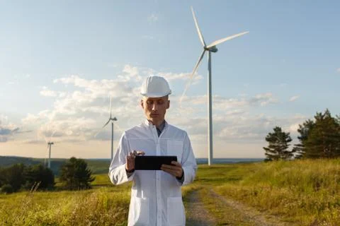 Engineer checks Wind Turbine system with a tablet. Alternative Energy. Wind farm Stock Photos