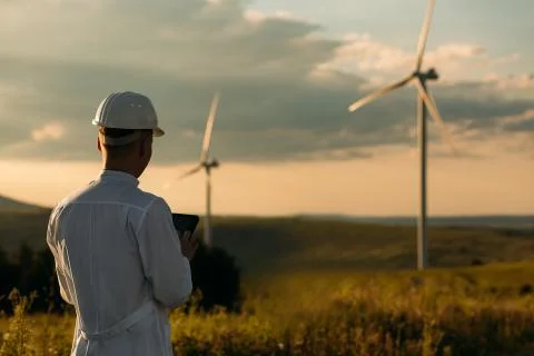 Engineer checks Wind Turbine system with a tablet. Alternative Energy. Wind farm Stock Photos