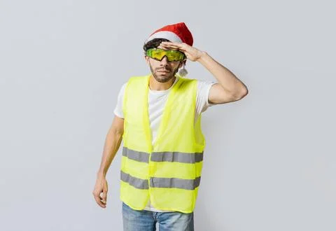 Engineer in christmas hat looking at something in the distance. Engineer in.. Stock Photos
