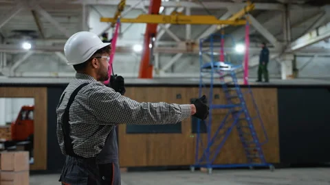 Engineer communicating with walkie talkie and giving instructions in factory Video stock 313090206