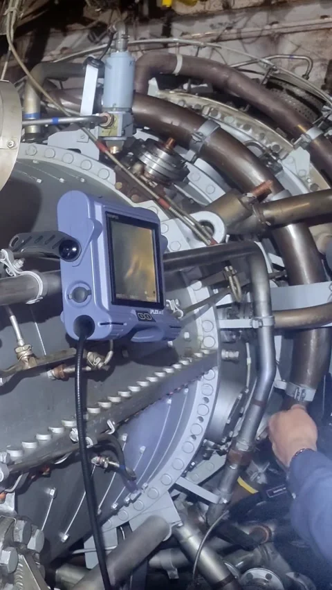Engineer conducts endoscopic analysis of turbine components, focusing on rotor Stock Footage 282599199