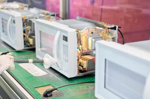 Engineer conducts microwave leakage testing on production line using a detector Fotos de archivo