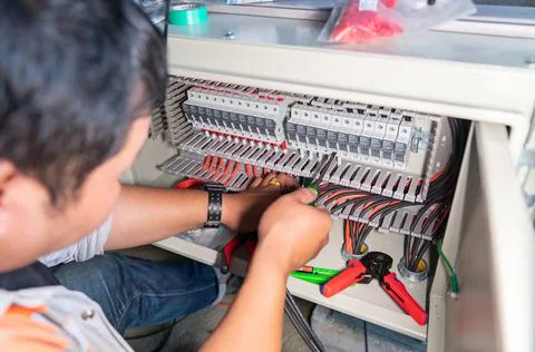 The engineer is connecting the power from the solar panel to the fuse set . Stock Photos