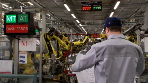 The engineer considers the production line scheme where robots collect Stock Footage 92197681