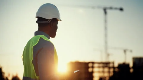 Engineer on construction site, black man using smartphone, typing message Stock Footage 318343043