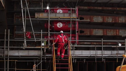 The engineer at the construction site climbs the stairs to the scaffolding Stock Footage 231215141
