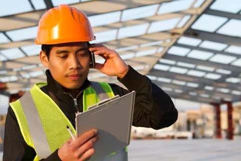 Engineer construction talking mobile phone under new building Stock Photos
