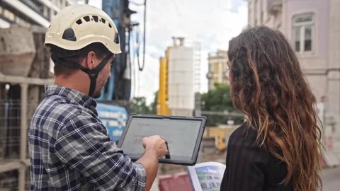 Engineer constructor discuss build plan. Man show construction site project. Stock Footage 271223254