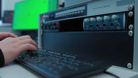 An engineer controlling a mixer and typing on a keyboard Stock Footage 277092615