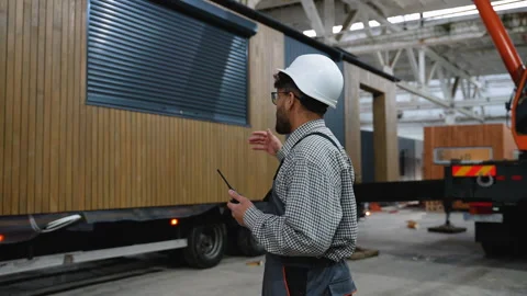 Engineer controlling modern prefabricated house transportation on truck in Video stock 313084986