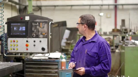 Engineer controlling the proper functioning of factory machinery Stock Footage 258805317