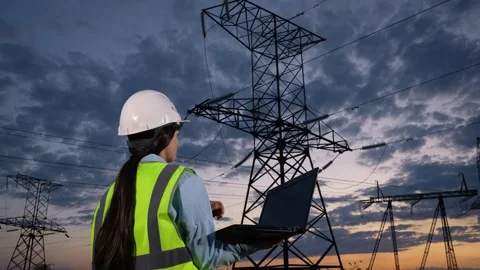 Engineer controls information on laptop walking to power transmission lines Stock Footage 250151246