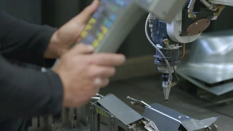 Engineer controls Laser Cutter machine with programming remote for automation Stock Footage