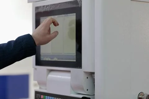 Engineer controls modern equipment by touchscreen Stock Photos