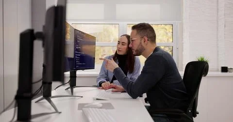 Engineer Creating Computer Code With Colleagues For PC Engineering Projects. Stock Photos