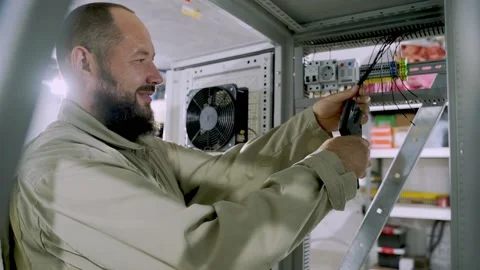 Engineer cutting off electrical wire with tool Stock Footage 155958121