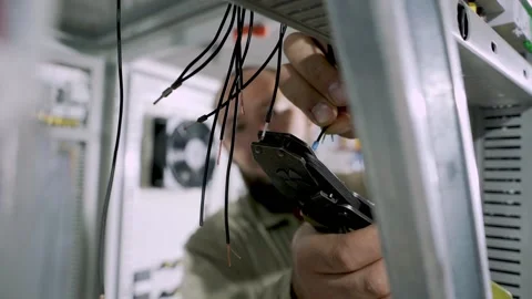 Engineer cutting off electrical wire with tool Stock Footage 156038812
