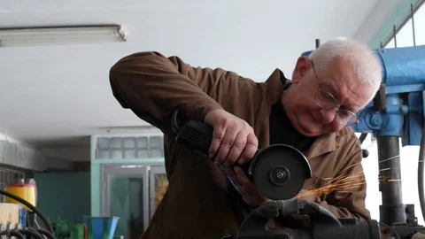 Engineer cutting metal using angle grinder while working in industrial worksh 库存影片 105839620