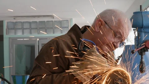 Engineer cutting metal using angle grinder while working in industrial worksh Stock Footage 105839640