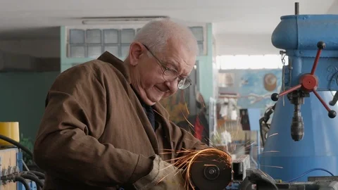 Engineer cutting metal using angle grinder while working in industrial worksh Видео 105839641