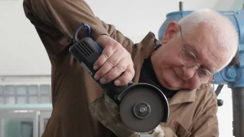 Engineer cutting metal using angle grinder while working in industrial worksh Stock-Footage 105839706