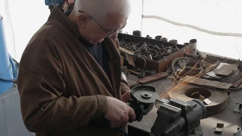 Engineer cutting metal using angle grinder while working in industrial worksh Vidéo 105839762