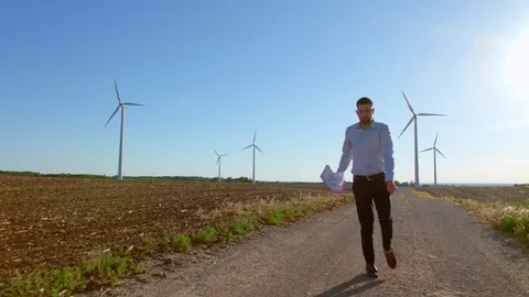 Engineer dances on windmills background. Video stock 76639478