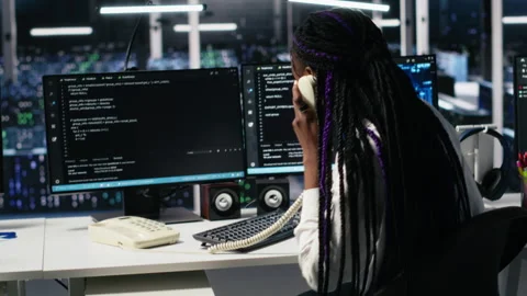 Engineer in data center answers telephone call, assisting users with AI Stock Footage 313566296
