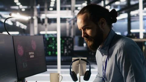 Engineer in data center frustrated by critical error popup on monitor Stock Photos