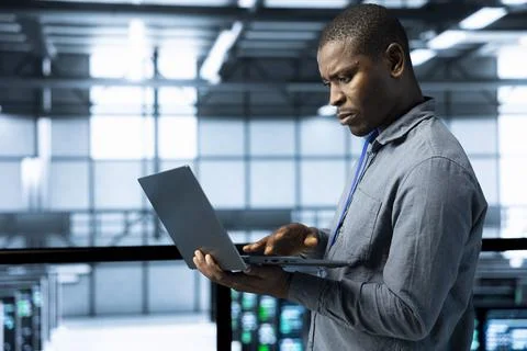 Engineer in data center operating laptop, deploying new server architectures 스톡 사진