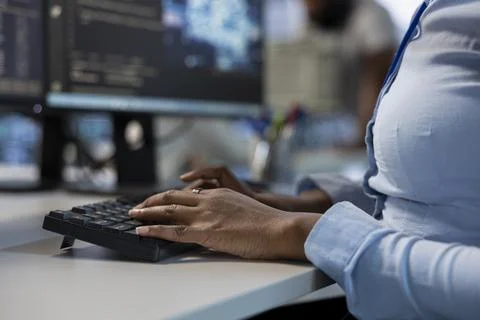 Engineer in data center typing on keyboard, optimizing IT infrastructure Stock Photos