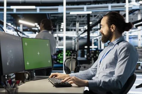 Engineer in data center using green screen mockup PC to update software Stock Photos