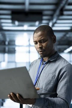 Engineer in data center using laptop adjusting power management settings 스톡 사진